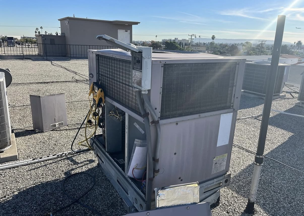 Rooftop packaged HVAC unit being serviced above the Inland Empire